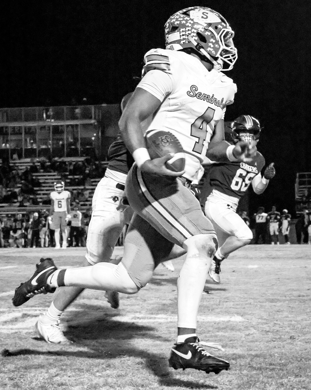 Left, Seminole QB Donavin Garfield scampers towards the end zone in Friday night’s first round playoff game with Heritage Hall. (Photo by Ben Schatzel)