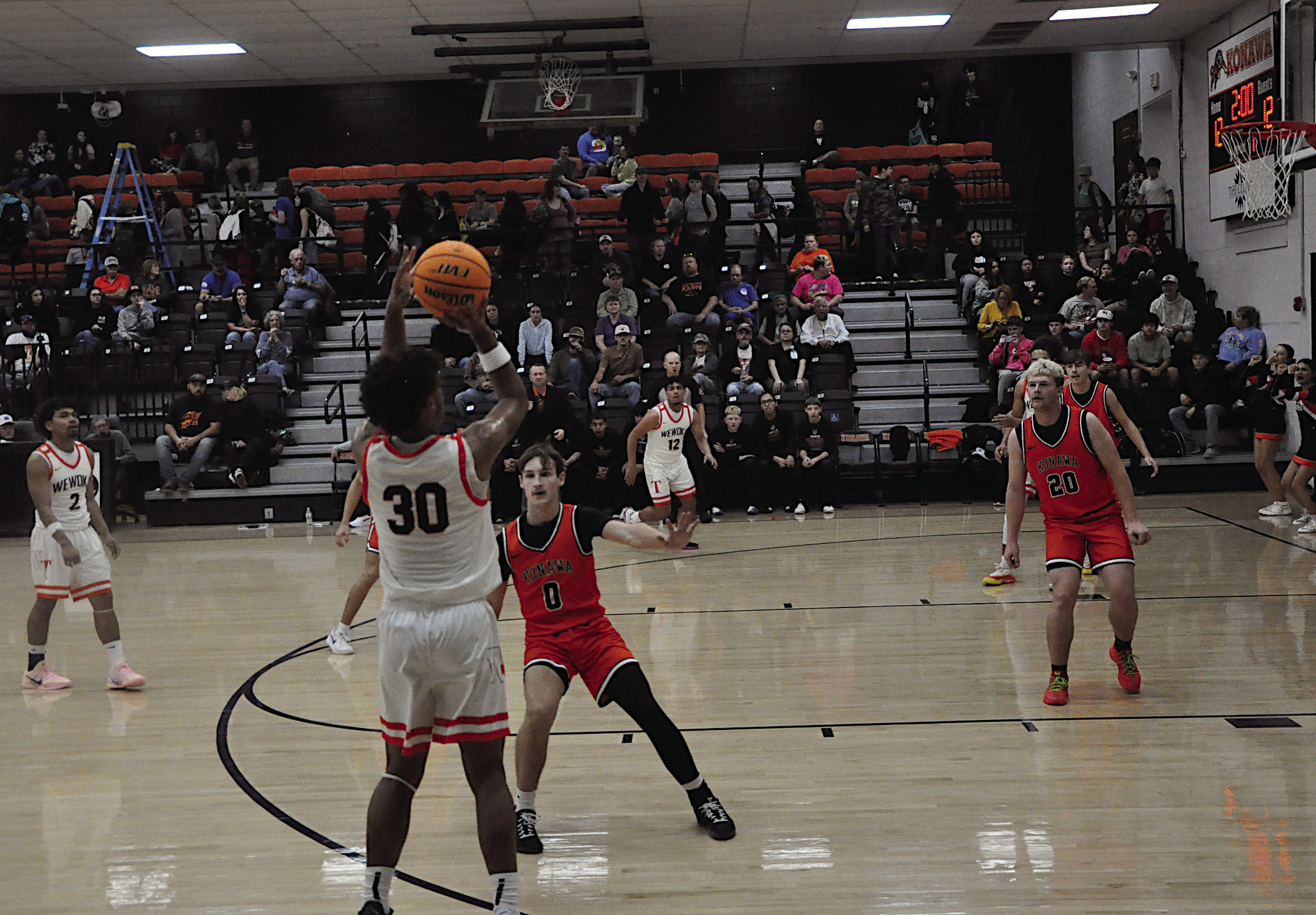 Wewoka Tiger Ladarius Woods shoots from behind the arch over Konawa Tiger Tegun Stalnaker Thursday afternoon. Wewoka won 71-26. Staff Photo by Bill Anderson