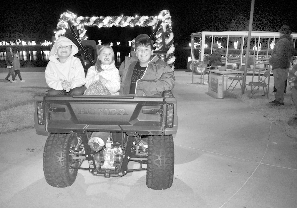 A group of youngsters smile excitedly as they ride in the back of a cart at the Seminole Chamber of Commerce parade of jeeps, carts and ATVs at Snowman Wonderland Tuesday evening. —Staff Photo by Andy Wilson