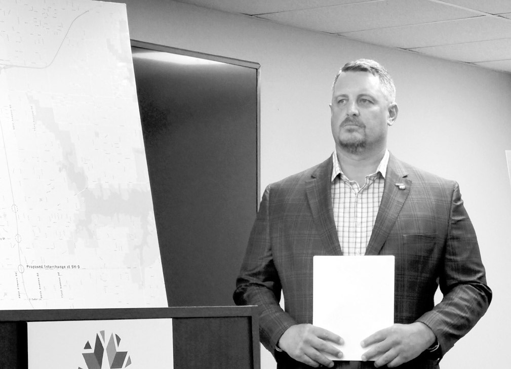 Oklahoma Turnpike Authority Executive Director Joe Echelle on Tuesday stands next to a map of the new route for the South Extension Turnpike in the Norman area. (Photo by Barbara Hoberock/Oklahoma Voice)