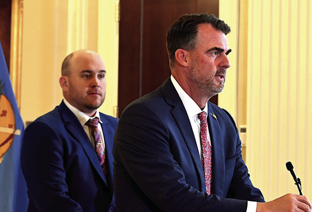 With House on Appropriations and Budget Committee Chairman Trey Caldwell standing behind him, Gov. Kevin Stitt speaks to reporters during a press conference Wednesday, May 28. The legislature overrode 47 of Stitt’s vetoes on Thursday. For complete cover