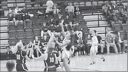 Staff Photo by Bill Anderson Konawa Lady Tiger Chloe Tebe goes up over the Elmore City defenders for the basket Tuesday night.