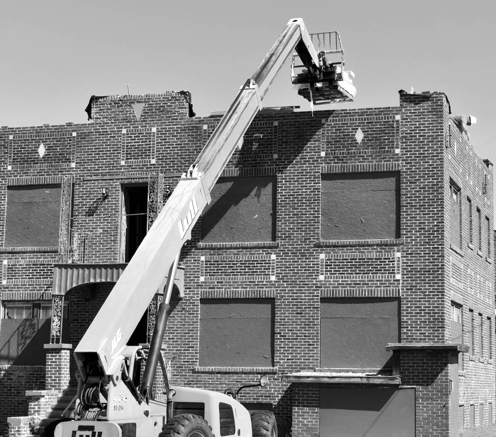 A worker was perched high upon the roof of the Van Sanford Apartments on Milt Phillips Monday as part of a renovation project by GuruStu of Tulsa. The complex sustained heavy damages in the May 2022 tornado. —Staff photo by Andy Wilson
