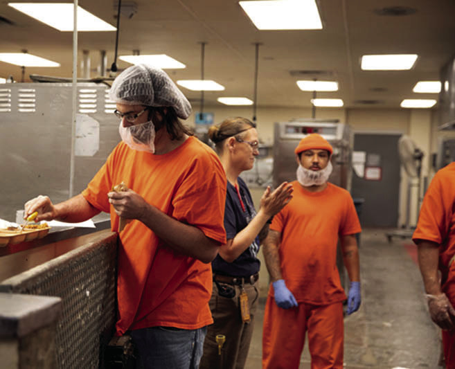 Prisoners are shown working in the kitchen at the Joseph Harp Correctional Center in Lexington. (Brent Fuchs/Oklahoma Watch)
