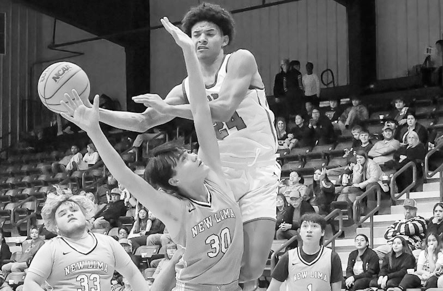 Varnum Whippet CJ Bernard goes up for the basket over New Lima Falcon Alex Leaver Tuesday night at the LRC Tournament. Varnum won 72-30. Courtesy Photo by Glen Bryan