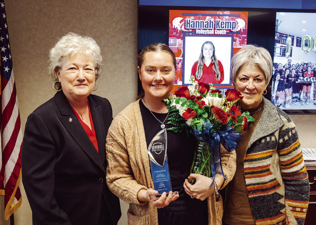 SSC President Lana Reynolds (left) and SSC Board of Regents Chair Marci Donaho (right) present Women’s Volleyball Head Coach Hannah Kemp (center) with a plaque and flowers to commemorate her 100th career win at Seminole State College during the Oct. 30 