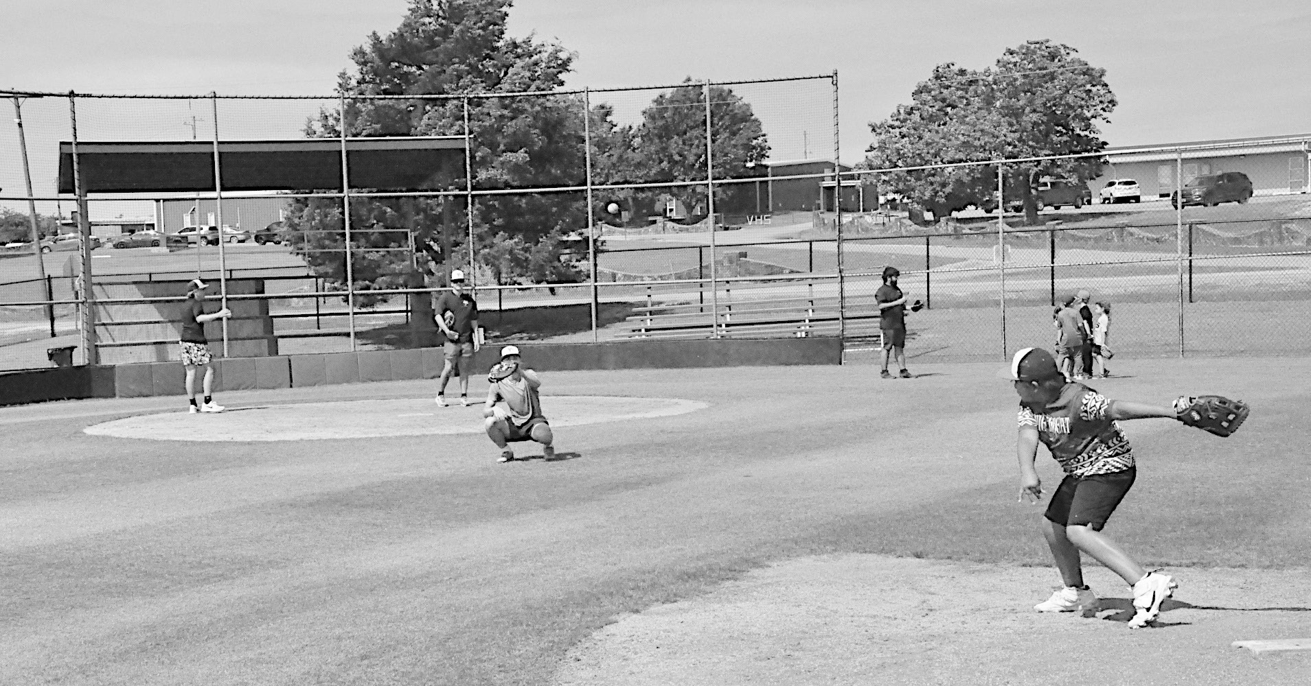 The Varnum coaching staff help the kids in the catcher’s position Monday. Kids rotated positions throughout the day. Staff Photo by Bill Anderson
