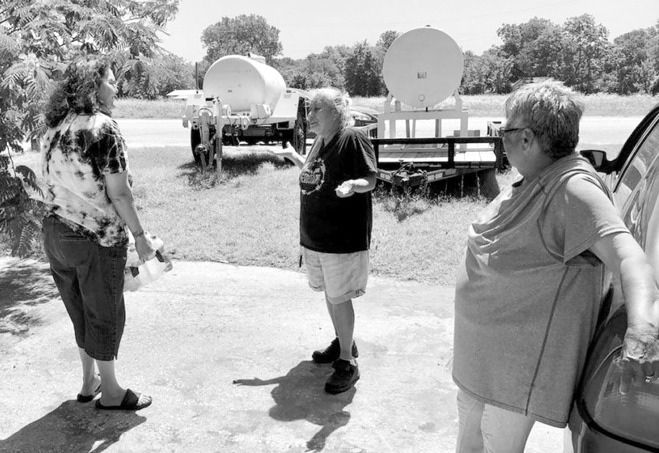 In this NonDoc photo taken in June 2022, Sasakwa Mayor Brenda Myrick hand delivers a case of water to town residents Peggy Osceola Davis and Amanda Gibson. Sasakwa has been beleaguered by water problems for many years and this week the Oklahoma Water Reso
