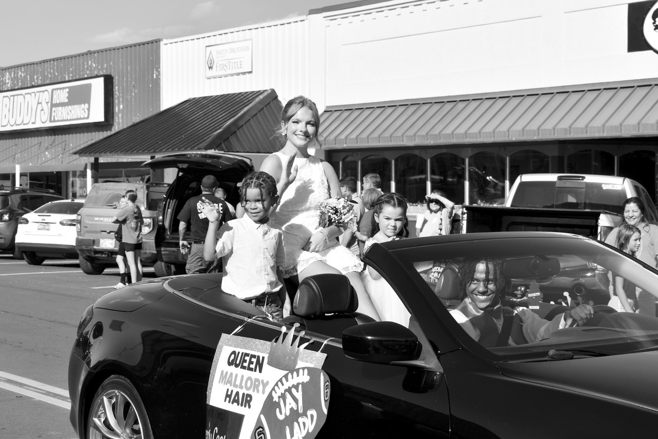 Seminole Homecoming Queen Mallory Hair, accompanied by Crown Bearer Jakobe Lawson and Flower Girl Everly Cook, waves to the crowd from a car driven by Homecoming King Jay Ladd in Friday’s annual Homecoming Parade in the downtown district. —Staff photo