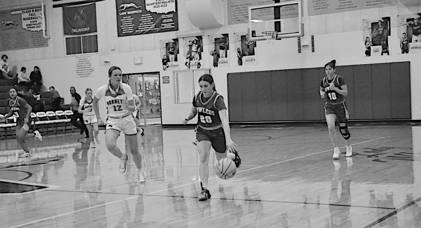 Bowlegs Lady Bison Kasin Kolander drives the ball down field against Macomb defender. Bowlegs lost 27-51. Staff Photo by Bill Anderson