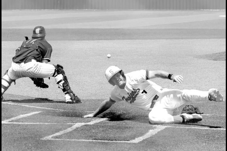 Seminole State Trojan WT Jones slides safely across home plate for the score. Courtesy Photo by Glen Bryan