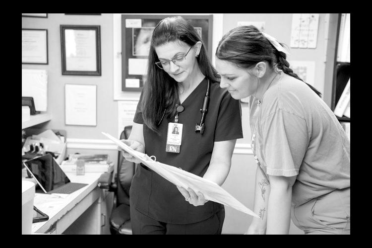 Lynaea McGee, a hospice case manager and Seminole State College student, consults with her daughter, Jaden McClellan, a certified nursing assistant, on Friday, May 1 at Featherstone Assisted Living in Ada. (Brent Fuchs/Oklahoma Watch)