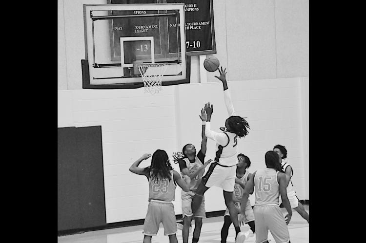 Seminole State Trojan Jaylan Jackson goes up and over the Langston defenders for the shot. Staff Photo by Bill Anderson