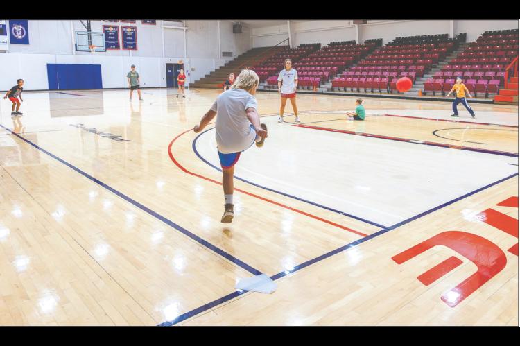 Right, Bobbi Leitha, Head Volleyball Coach at Seminole State College, led the Wild Child Fitness Camp, which kept students active through games, exercises and team-building activities. Campers are pictured playing kickball in the Raymond Harber Field House. The camp was held earlier this month at SSC and provided multiple activities for area students up to eighth grade. (SSC photo)