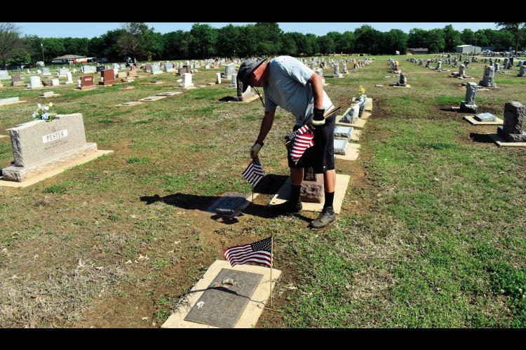 A worker for the City of Seminole places flags on the graves of veterans in Maple Grove Cemetery on Friday. A special Memorial Day service will be held on Monday, May 26 beginning at 10 a.m. in the historic O.D. Strother Chapel. Brigadier General Brad Car