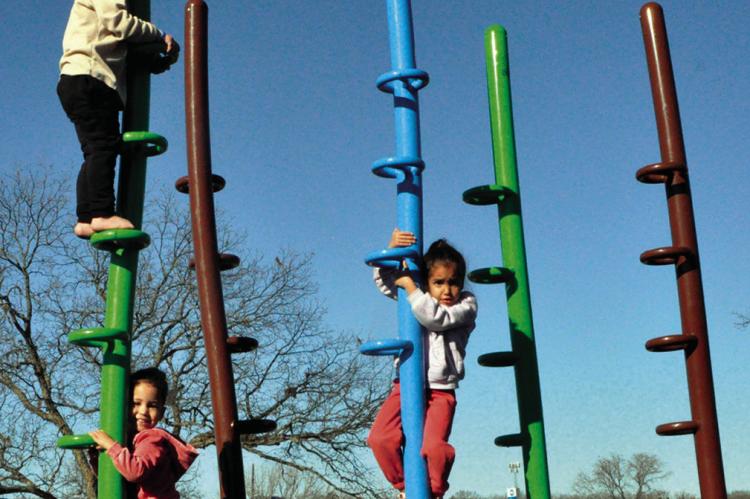 Chance Morgan, Royalty Moore and Joey Moore took advantage of Wednesday’s unseasonably warm temperatures by climbing around in Boom Town Playground, located in the Seminole Municipal Park. —Staff Photo by Bill Anderson