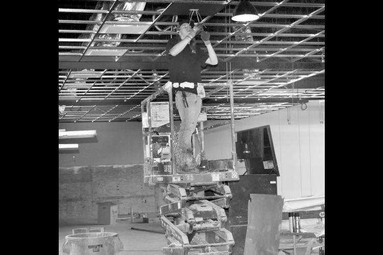 A worker perches atop a forklift Monday inside the future Hey Seminole Entertainment Center on Highway 9, operated by HeyDay Entertainment. On Monday, the company announced that its Norman location would close at the end of this month. —Staff Photo by Andy Wilson