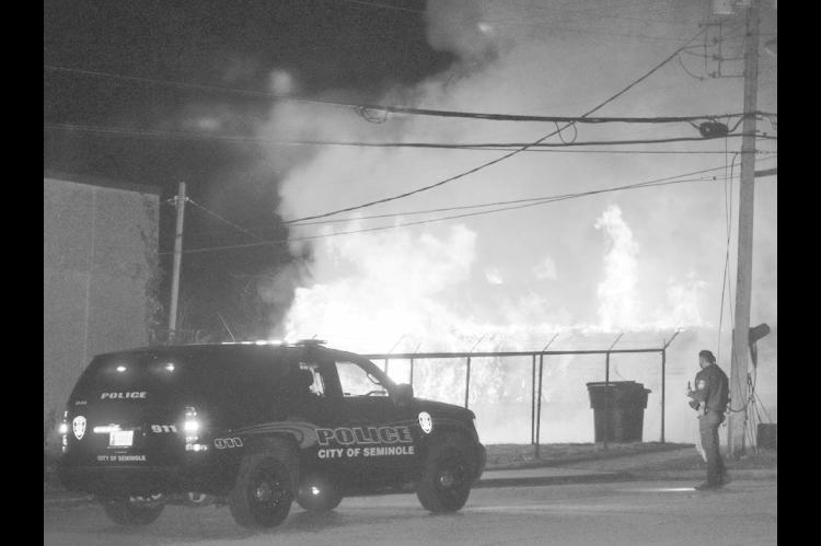 A house on Oak Street, just north of Broadway, went up in flames early Saturday evening shortly after the start of the Seminole Christmas Parade. Investigators say the blaze was considered arson, and one arrest has been made. (Staff photo by Andy Wilson)