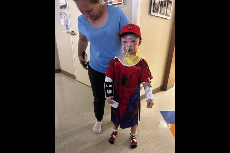 Ryker Corona, dressed in a Spiderman costume, takes a walk at Integris Baptist Hospital in Oklahoma City where he is undergoing treatment for second degree burns he sustained in an explosion at the Jasmine Moran Children’s Museum on Saturday, June 21. (