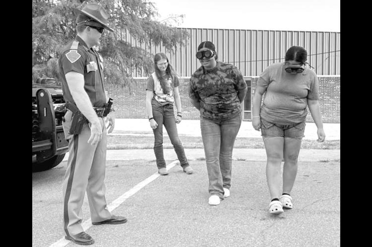 On Wednesday, Wewoka High School students participated in an impaired driving simulation presented by the Okla. County Sheriff’s Department. As part of the simulation, students wore impairment-simulation goggles while completing a mock field sobriety test. —Courtesy photo