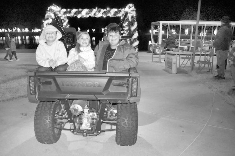 A group of youngsters smile excitedly as they ride in the back of a cart at the Seminole Chamber of Commerce parade of jeeps, carts and ATVs at Snowman Wonderland Tuesday evening. —Staff Photo by Andy Wilson