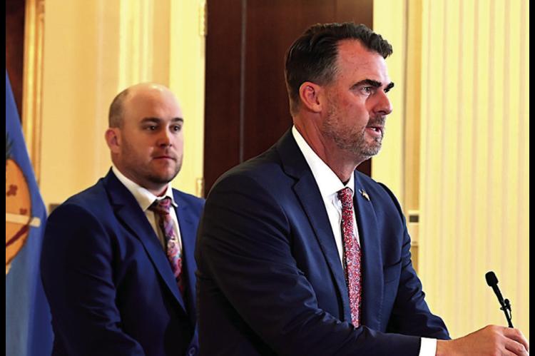 With House on Appropriations and Budget Committee Chairman Trey Caldwell standing behind him, Gov. Kevin Stitt speaks to reporters during a press conference Wednesday, May 28. The legislature overrode 47 of Stitt’s vetoes on Thursday. For complete cover