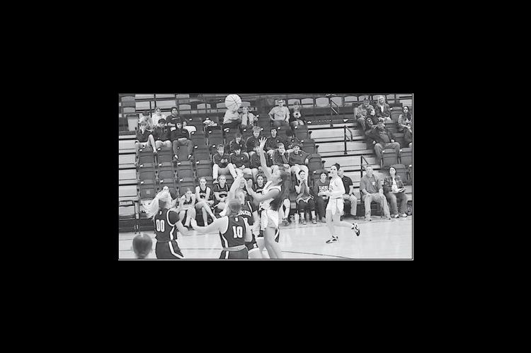 Staff Photo by Bill Anderson Konawa Lady Tiger Chloe Tebe goes up over the Elmore City defenders for the basket Tuesday night.