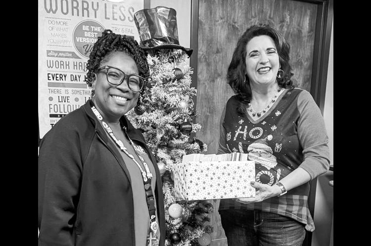 Se’Naqua Hildreth (left), the Voluntary Service Assistant with the Center for Development and Civic Engagement at the VA Medical Center, accepts holiday greeting cards signed by the SSC campus community from Professor of History Marta Osby. (Photo provi