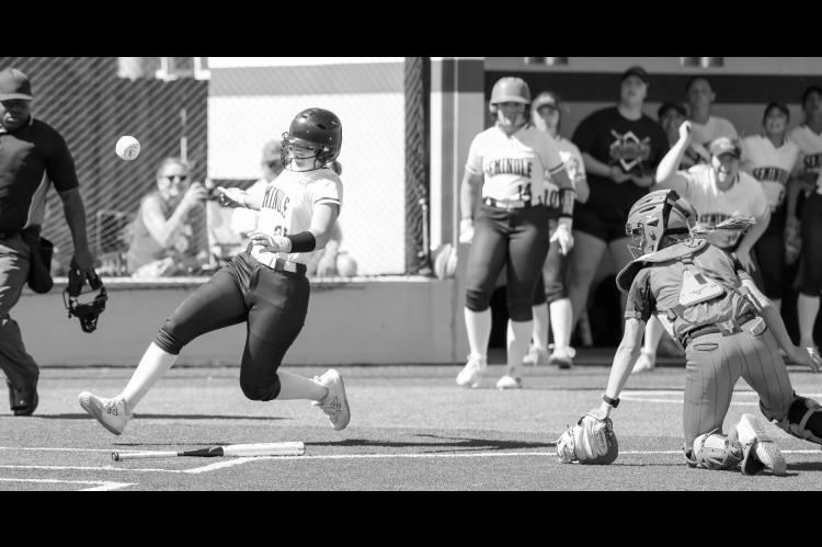 Seminole State Lady Trojan Mckenzier Cothran scores a run as the ball gets past the catcher Monday. Courtesy photo by Glen Bryan