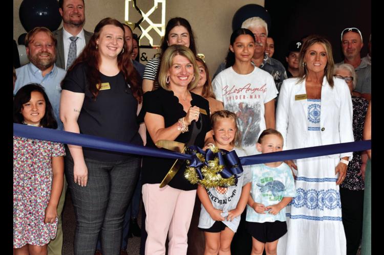 Tanya Friend of Stuart &amp; Clover Title in Seminole cuts the ribbon during open house ceremonies Wednesday afternoon. Others pictured include Dakota Jones, Mila Meeks, Wilo Meeks and Juliana States. The company is located at 205 N. Main. —Staff Photo 
