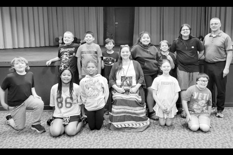 Above left, celebrated author Dayna Carpitcher with the Butner 5th Grade Class and their teacher, Mr. Dan “Butch” Houser. Above right, Carpitcher donated a copy of her book to Butner, which was accepted by Principal Karla Banks. Dayna is author of the book “The Seminole People, Culture and History.” The author, a member of the Seminole Nation of Oklahoma, read sections of her book to the students and explained that the regalia she was wearing is part of her culture. (Courtesy photos)