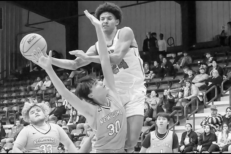 Varnum Whippet CJ Bernard goes up for the basket over New Lima Falcon Alex Leaver Tuesday night at the LRC Tournament. Varnum won 72-30. Courtesy Photo by Glen Bryan
