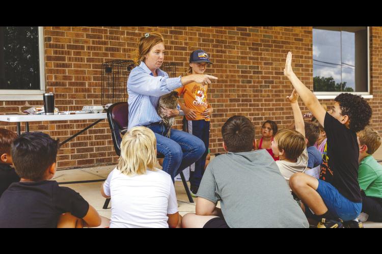 Seminole State College Associate Professor of Agriculture Wendy Rich gives campers a hands-on lesson in caring for chickens outside the Enoch Kelly Haney Center. The activity was part of the NextGen Agriculture section of Kids on Campus event July 13-16. —SSC photo