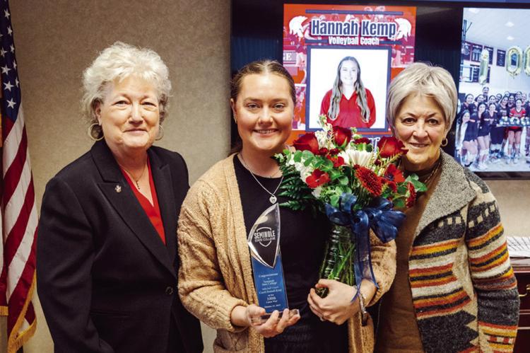 SSC President Lana Reynolds (left) and SSC Board of Regents Chair Marci Donaho (right) present Women’s Volleyball Head Coach Hannah Kemp (center) with a plaque and flowers to commemorate her 100th career win at Seminole State College during the Oct. 30 