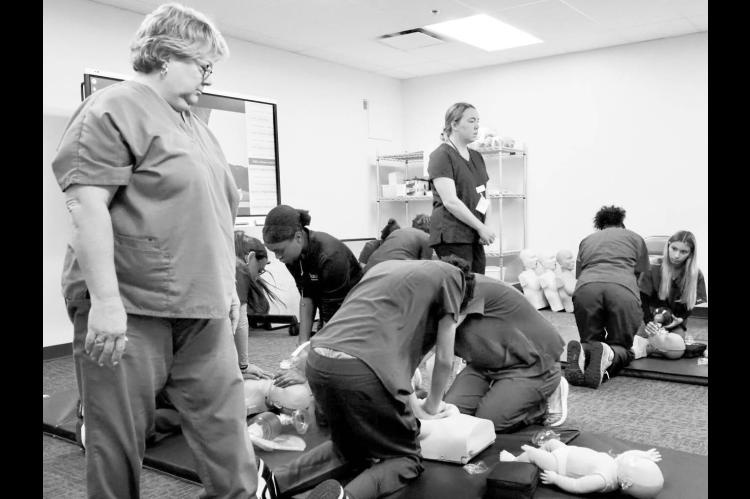 Students in the certified nursing assistant program at Francis Tuttle’s Rockwell campus practice CPR skills while instructors supervise and offer guidance on Sept. 5, 2025. (Photo by Emma Murphy/Oklahoma Voice)