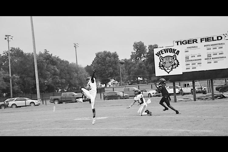 Staff Photo by Bill Anderson Konawa Tiger Layne Akerman tips the ball into the hands of Wewoka Tiger Bill Stephens for the touchdown Friday.