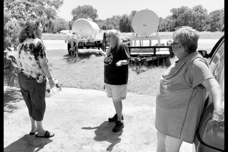 In this NonDoc photo taken in June 2022, Sasakwa Mayor Brenda Myrick hand delivers a case of water to town residents Peggy Osceola Davis and Amanda Gibson. Sasakwa has been beleaguered by water problems for many years and this week the Oklahoma Water Reso