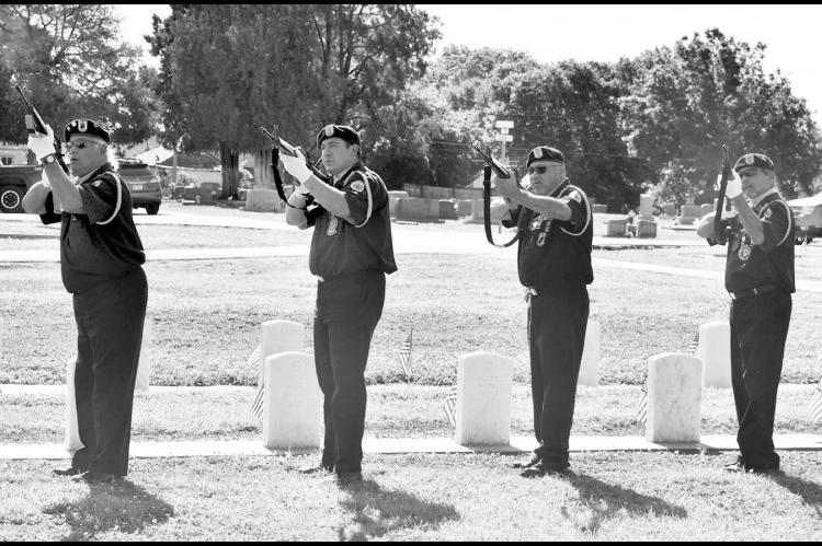 Left, members of the Seminole Nation Honor Guard fire a three-volley salute in honor of fallen military members at Maple Grove Cemetery Monday Morning. The salute was part of the Annual Memorial Day Service, sponsored by the Maple Grove Cemetery Chapel Association. Below left, Brody Haley plays “Taps” and the First United Methodist Church Joybells play the song “America” during the service. —Staff Photos by Andy Wilson