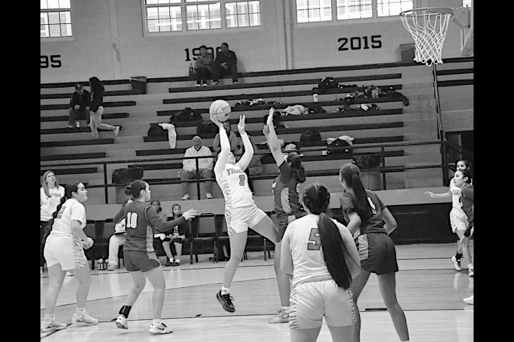 Wewoka Lady Tiger Leila Scott shoots the fade-aaway shot over the Anadarko defender Tuesday. Staff Photo by Bill Anderson