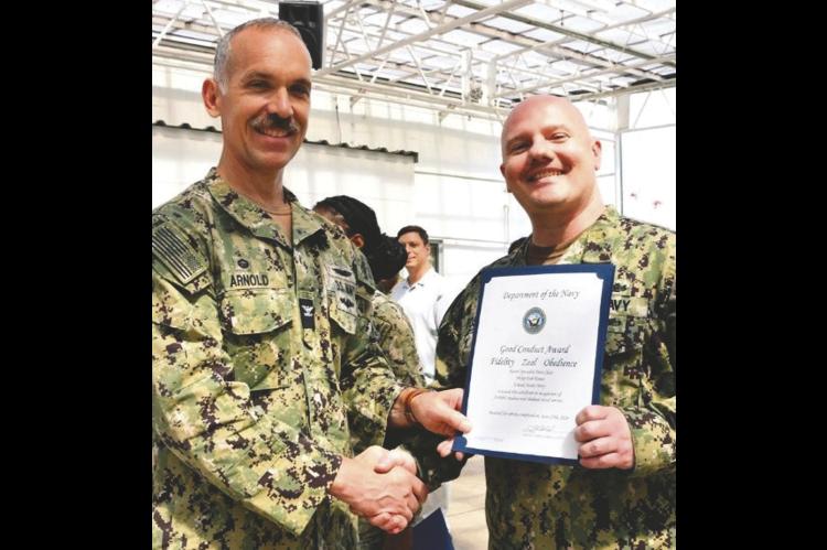 Petty Officer 1st Class Philip Foster (right), a native of Bethel Acres, Oklahoma, received a Navy Good Conduct Medal (NGCM) while serving at Fleet Mail Center Yokohama. This was Foster’s sixth time to receive the medal. —Photo courtesy US Navy