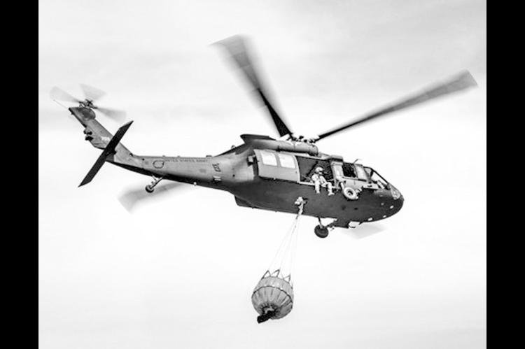 An Oklahoma Army National Guard UH-60 Black Hawk flies over the 702 Fire in Blaine County, Oklahoma after dropping more than 600 gallons of water on the fire, July 16, 2022. The Oklahoma National Guard is supporting the Oklahoma Forestry Services and loca