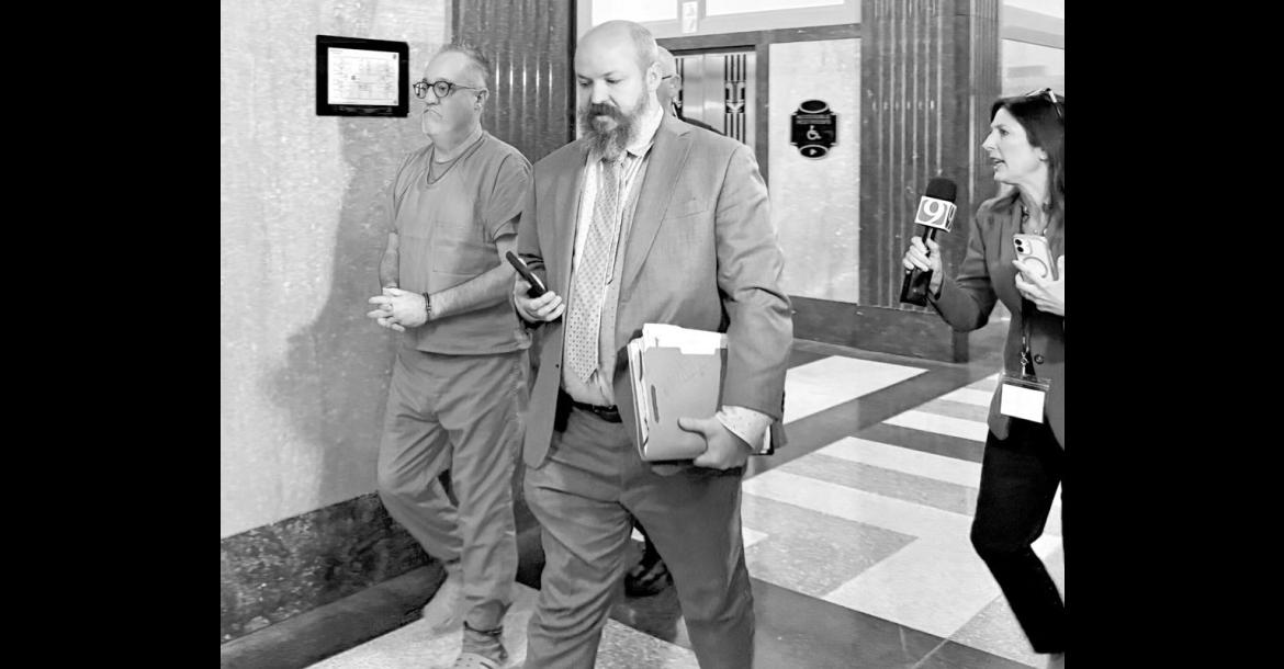 Brent Swadley, left, escorted by one of his attorneys and a police officer, enters a courtroom at the Oklahoma County Courthouse on Oct. 21, 2026, for his sentencing after being convicted for defrauding the state. (Photo by Emma Murphy/Oklahoma Voice)