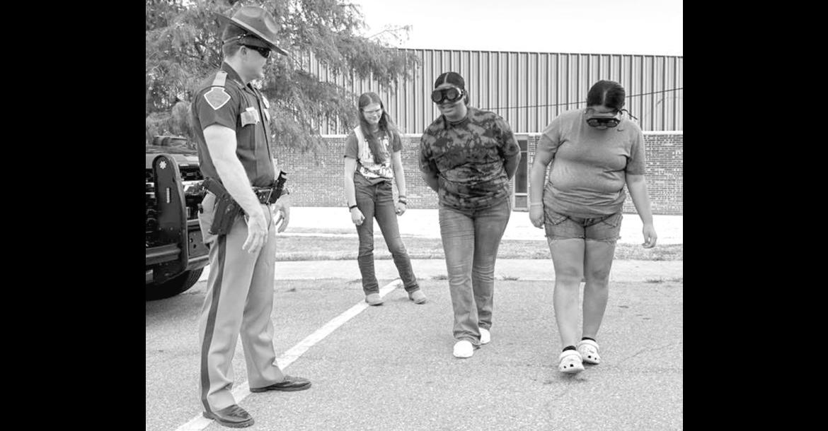 On Wednesday, Wewoka High School students participated in an impaired driving simulation presented by the Okla. County Sheriff’s Department. As part of the simulation, students wore impairment-simulation goggles while completing a mock field sobriety test. —Courtesy photo