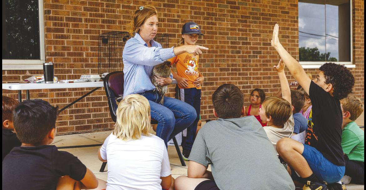 Seminole State College Associate Professor of Agriculture Wendy Rich gives campers a hands-on lesson in caring for chickens outside the Enoch Kelly Haney Center. The activity was part of the NextGen Agriculture section of Kids on Campus event July 13-16. —SSC photo