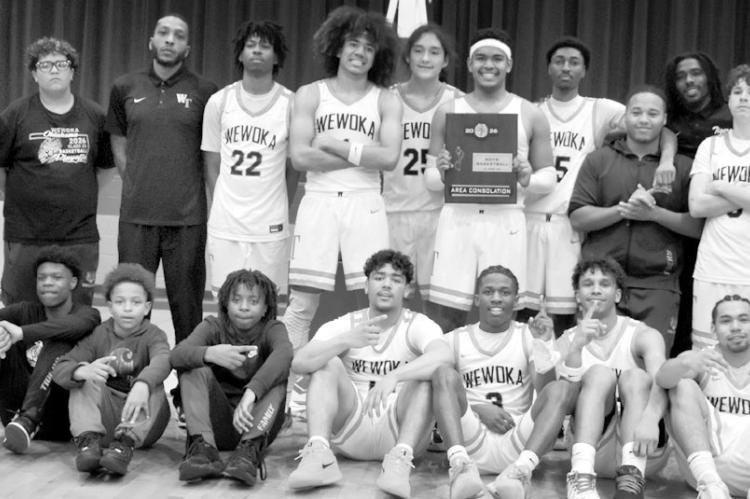 The Wewoka Tiger basketball team holds the plaque for their area consolation victory over Pocola Saturday night. They now advance to the state championship tournament Thursday. —Staff Photo by Andy Wilson