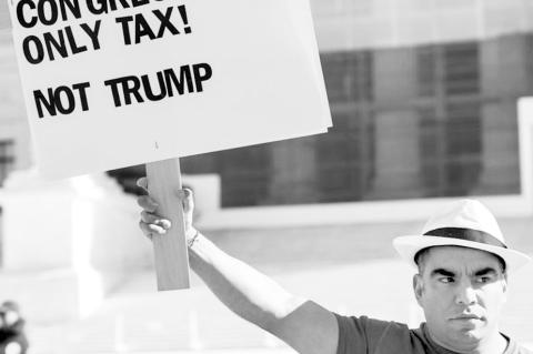 Protestor in front of the Supreme Court holds a sign arguing that only Congress has the power to impose a tariff. By Taylor Ann Barnes / Gaylord News