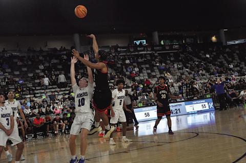 Wewoka Tiger Mike Piza goes up and over his defender Thursday night. Wewoka won 68-63. Staff Photo by Bill Anderson