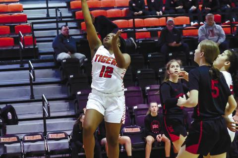 Konawa’s Zackary Reavis leaps high between two defenders