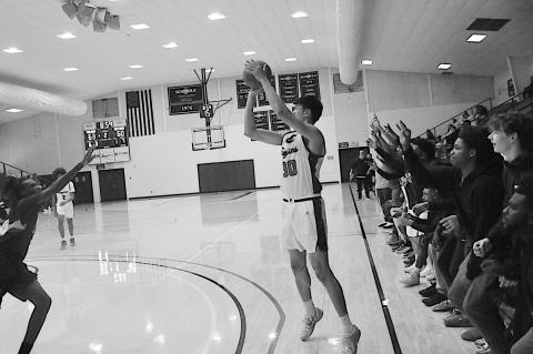 Seminole State Trojan Ming-Hsueh Cheng takes the shot from three-point range with teammates cheering him on Monday night. Staff Photo by Bill Anderson