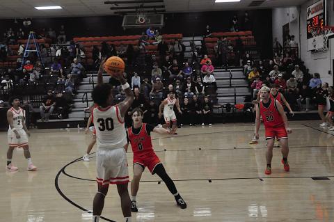 Wewoka Tiger Ladarius Woods shoots from behind the arch over Konawa Tiger Tegun Stalnaker Thursday afternoon. Wewoka won 71-26. Staff Photo by Bill Anderson